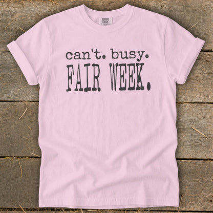 Pink t-shirt with black text that says "can't. busy. FAIR WEEK."