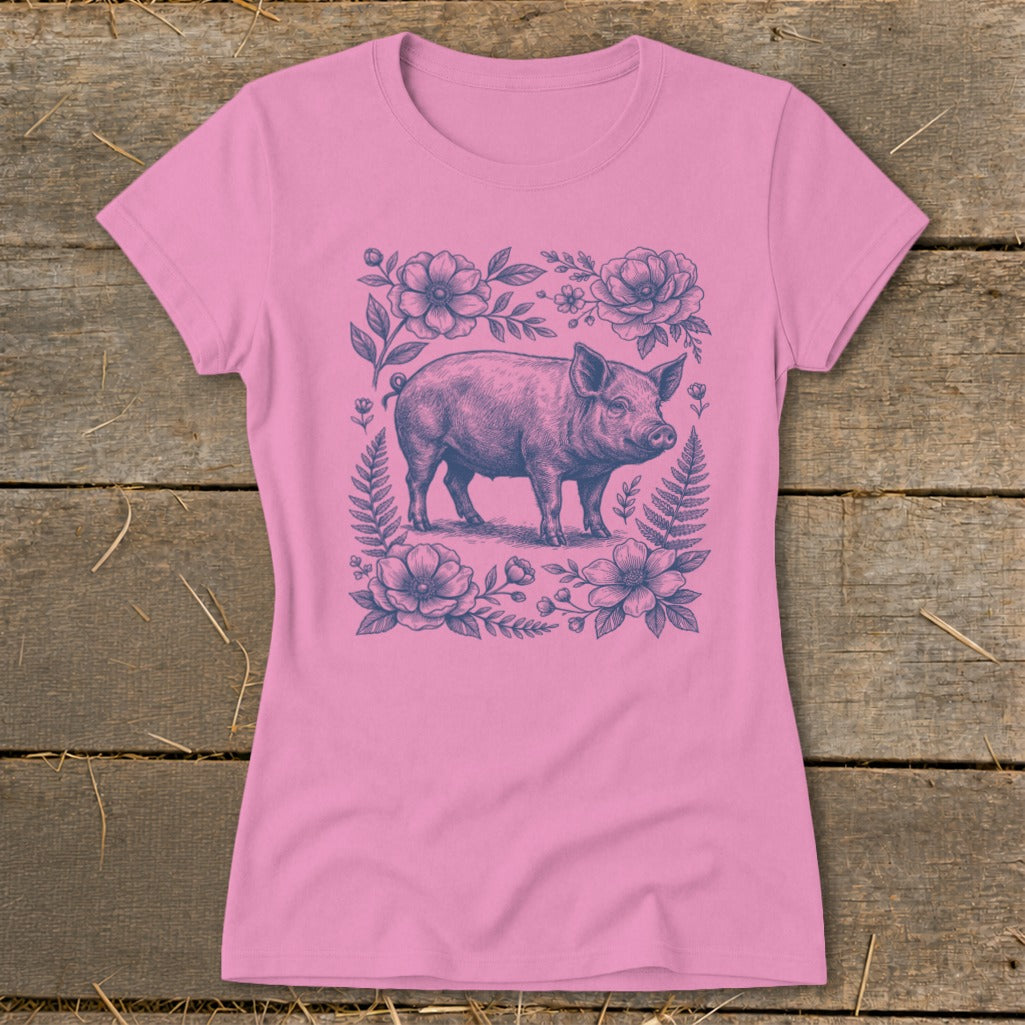 Pink t-shirt with a blue line drawing of a pig surrounded by flowers and ferns.