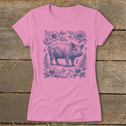 Pink t-shirt with a blue line drawing of a pig surrounded by flowers and ferns.