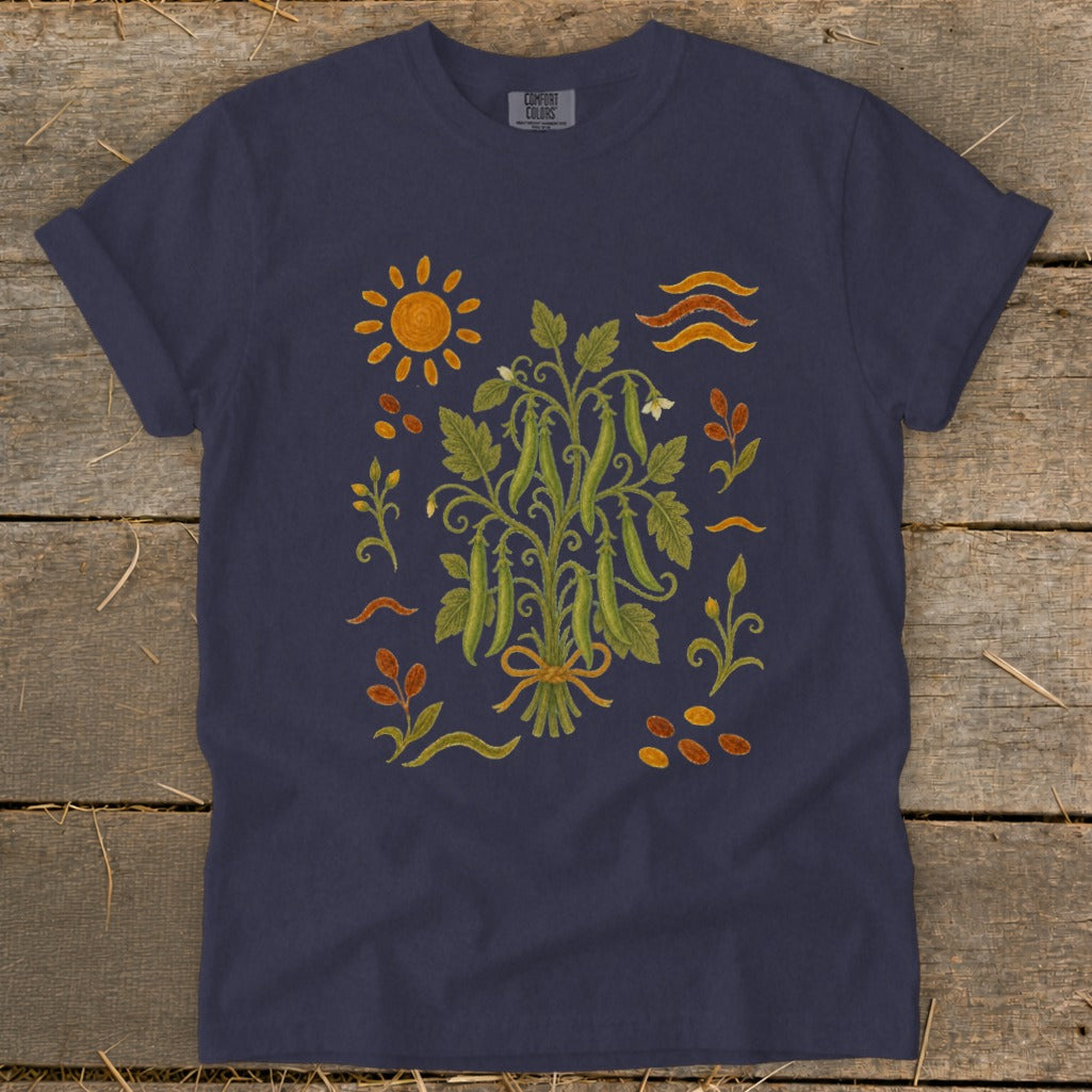 Navy t-shirt with a folk art illustration of a pea plant, sun, and seeds.