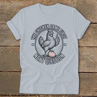 Light blue t-shirt with a chicken and egg graphic and text "The chicken came first. Next question."