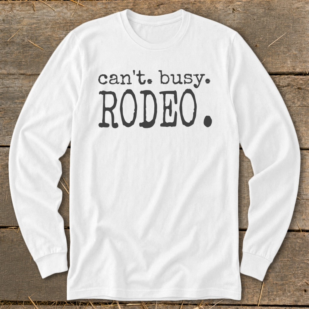 White long-sleeve shirt with "can't. busy. RODEO." text in black.