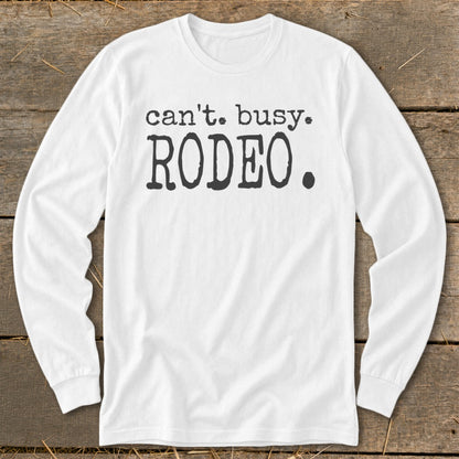White long-sleeve shirt with "can't. busy. RODEO." text in black.