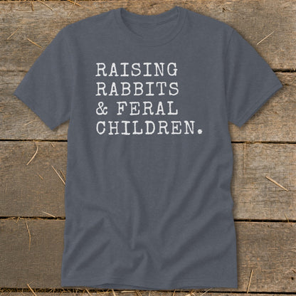 Dark grey t-shirt with white text reading "RAISING RABBITS & FERAL CHILDREN."