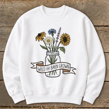 White sweatshirt with a mason jar filled with wildflowers and a banner reading "Wild and Barn Grown".