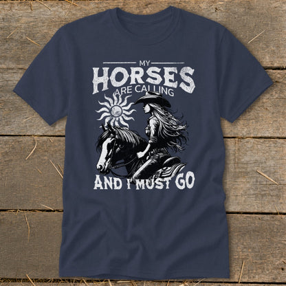Dark navy t-shirt with graphic of a woman riding a horse, text reads "MY HORSES ARE CALLING AND I MUST GO".