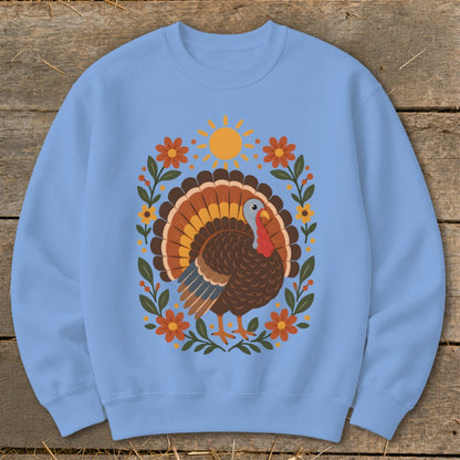 Light blue sweatshirt with a graphic of a turkey surrounded by flowers and a sun.