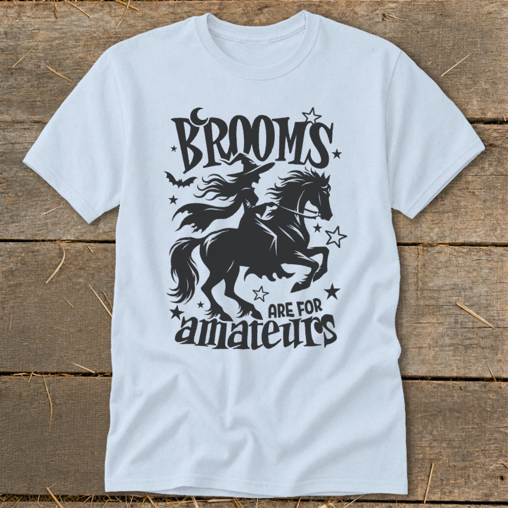 Light blue t-shirt with black graphic of witch on horse, text "Brooms are for amateurs".