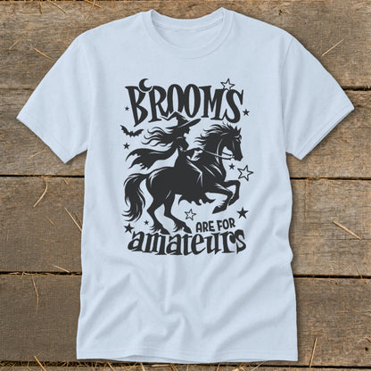 Light blue t-shirt with black graphic of witch on horse, text "Brooms are for amateurs".