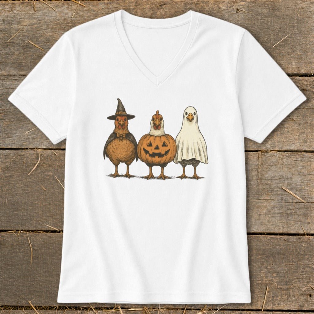 Three chickens dressed in Halloween costumes: witch hat, pumpkin, and ghost.