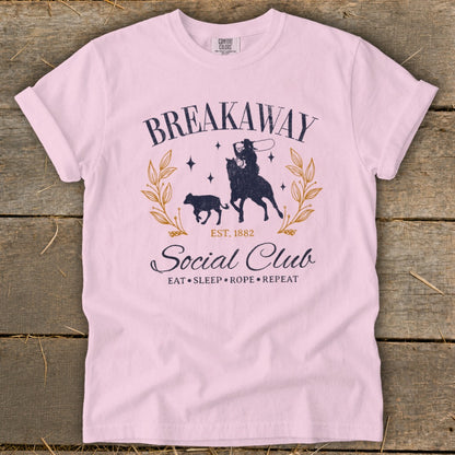 Pink t-shirt with "Breakaway Social Club EST. 1882 Eat Sleep Rope Repeat" graphic.