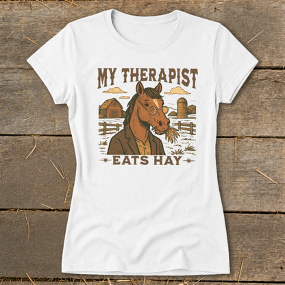 White t-shirt with graphic of horse in glasses and suit eating hay, text "My Therapist Eats Hay".