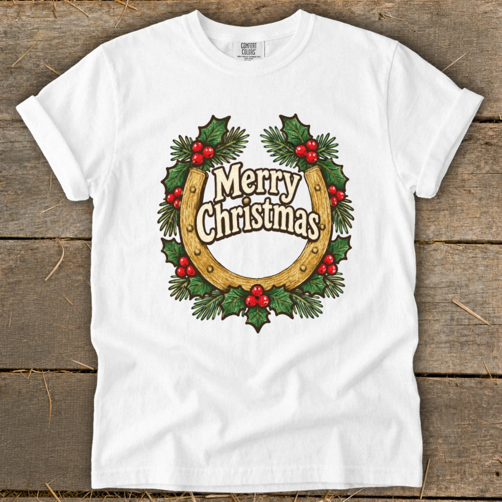 White t-shirt with a horseshoe wreath featuring "Merry Christmas" text and holly berries.