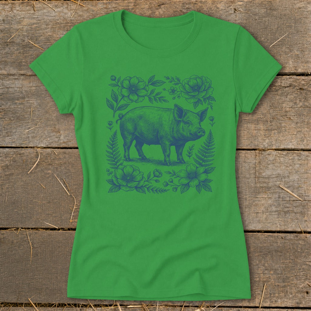Green t-shirt with blue pig and floral illustration in the center.