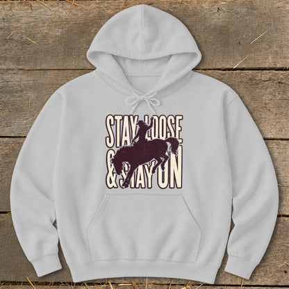 Light grey hoodie with "STAY LOOSE & STAY ON" text and cowboy silhouette on horse.