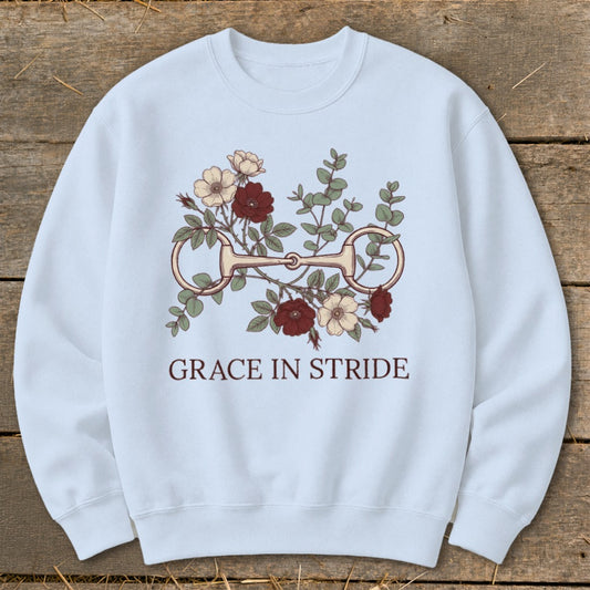 Light blue sweatshirt with equestrian bit and floral design, text reads "GRACE IN STRIDE".