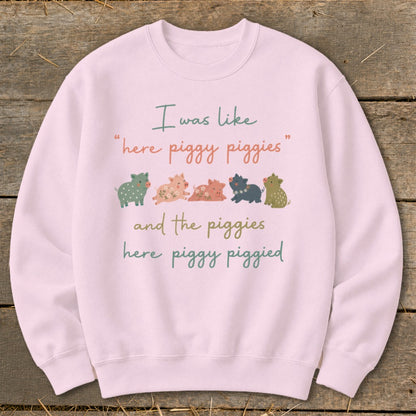 Pink sweatshirt with illustration of five pigs and text "I was like 'here piggy piggies' and the piggies here piggy piggied".