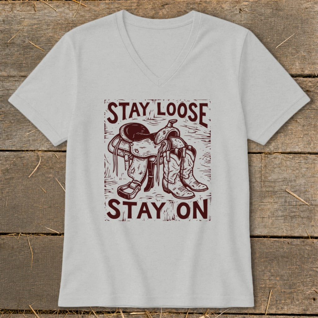 Gray v-neck t-shirt with a graphic of a saddle and cowboy boots, reading "STAY LOOSE STAY ON".