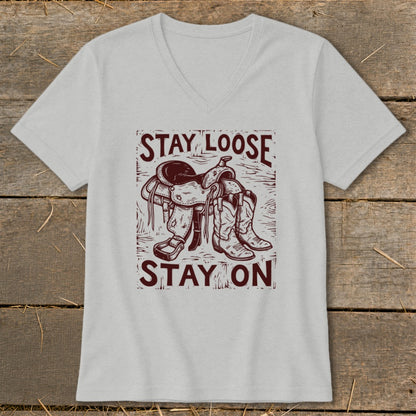 Gray v-neck t-shirt with a graphic of a saddle and cowboy boots, reading "STAY LOOSE STAY ON".