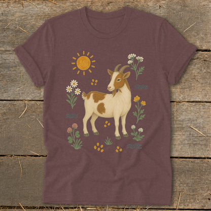 Brown and white goat illustration with sun, flowers, and waves on a maroon shirt.