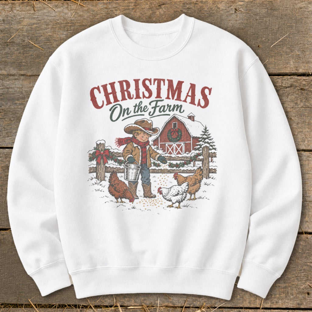 "Christmas On the Farm" graphic on a white sweatshirt with a boy feeding chickens.