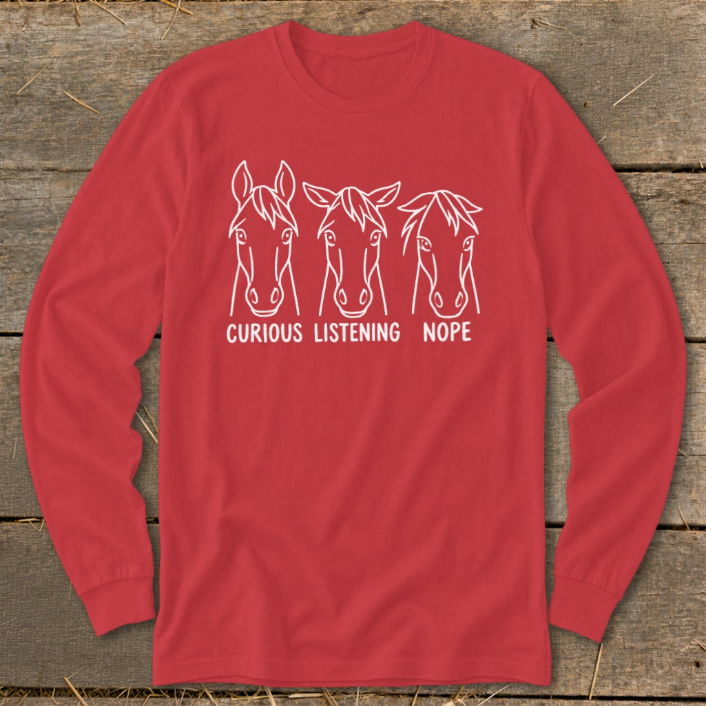 Red long-sleeve t-shirt featuring three white horse head line drawings labeled Curious, Listening, and Nope.