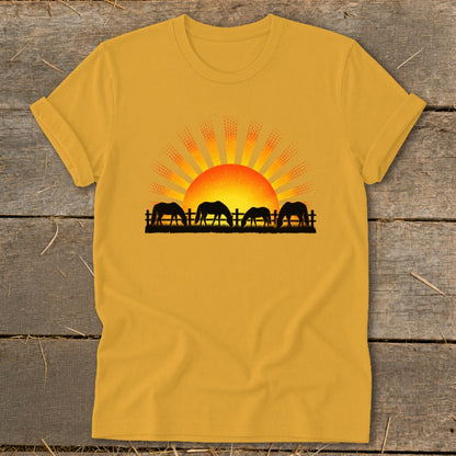 Yellow t-shirt with four horses grazing in front of a sunrise graphic.