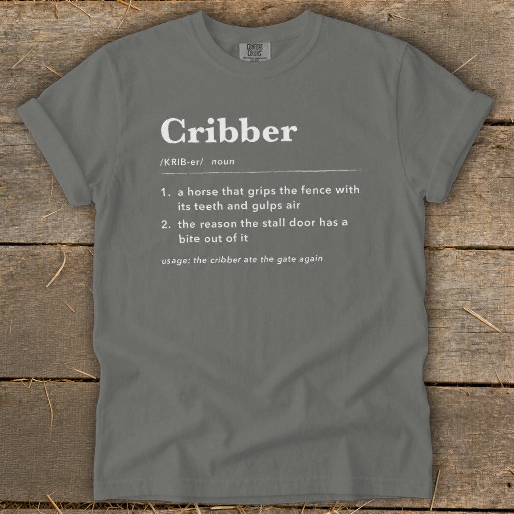 Dark gray t-shirt with white dictionary definition text for the word Cribber printed on the chest.