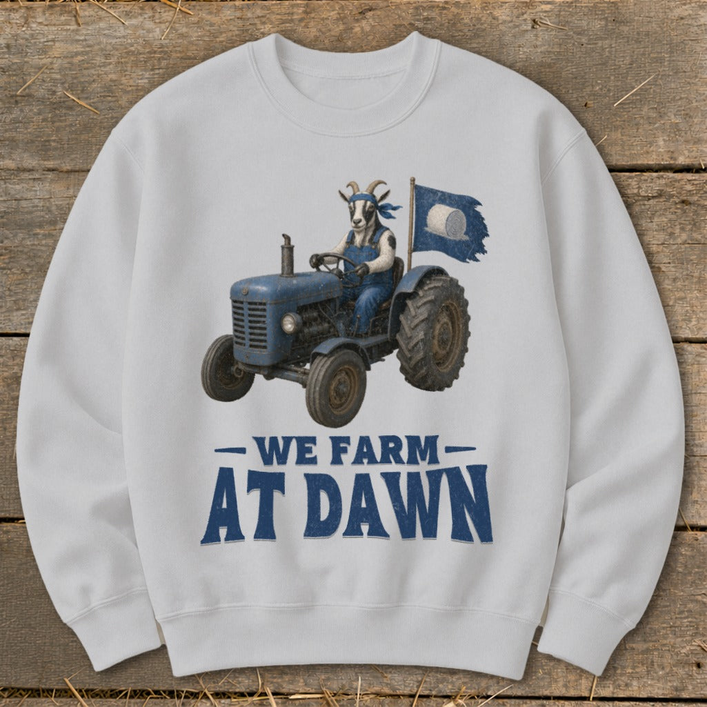Goat in overalls driving a tractor with hay bale flag, text "We Farm At Dawn".