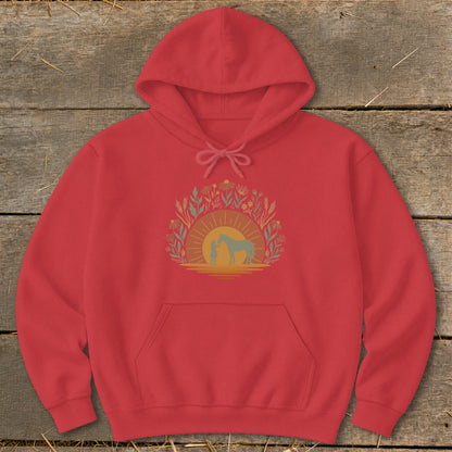 Red hoodie with a graphic of a person and horse at sunset surrounded by foliage.
