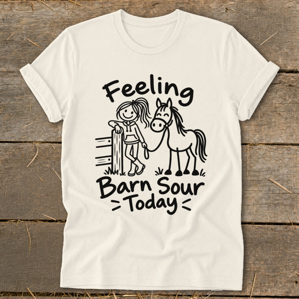 "Feeling Barn Sour Today" text on a cream t-shirt with stick figure girl and horse.