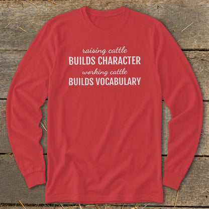 Red long-sleeve shirt with text: raising cattle BUILDS CHARACTER, working cattle BUILDS VOCABULARY.