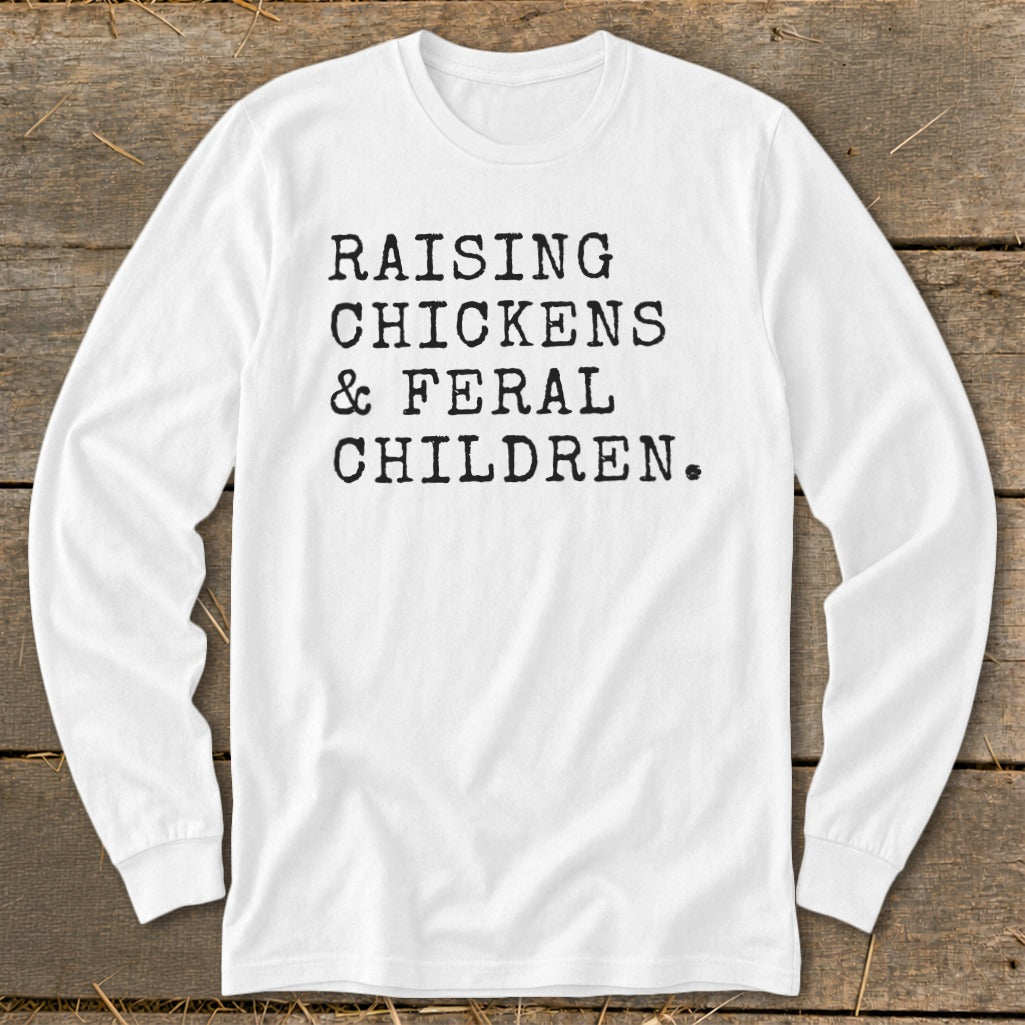 White long-sleeve shirt with black text: "Raising Chickens & Feral Children."