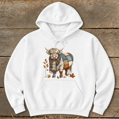 White hoodie with Highland cow graphic wearing a plaid scarf and patchwork blanket.