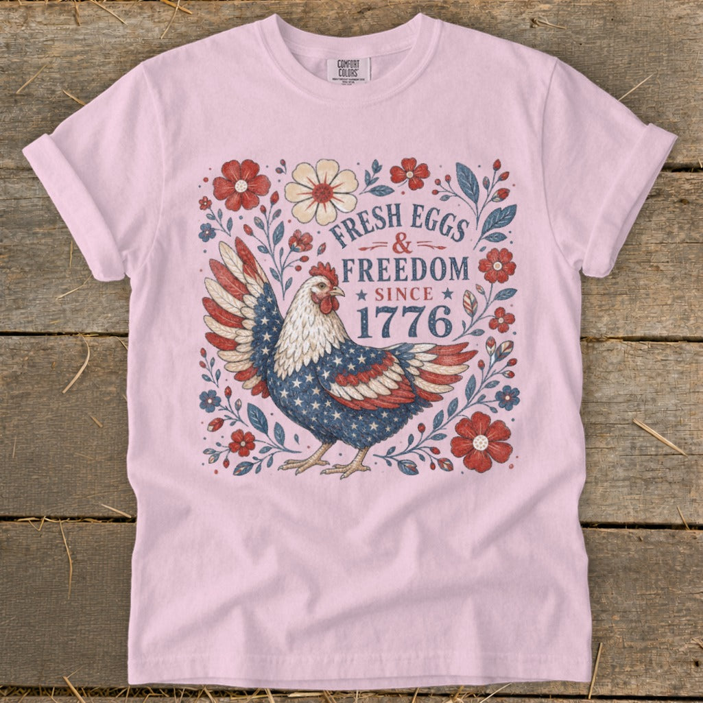 Pink t-shirt with patriotic chicken and "Fresh Eggs & Freedom Since 1776" text.