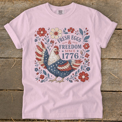 Pink t-shirt with patriotic chicken and "Fresh Eggs & Freedom Since 1776" text.