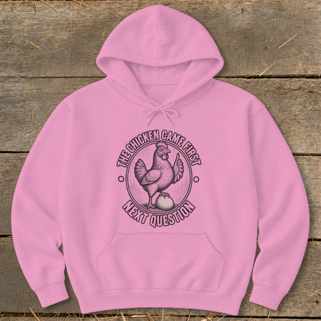 Pink hoodie with a circular graphic of a chicken on an egg, text reads "THE CHICKEN CAME FIRST NEXT QUESTION".