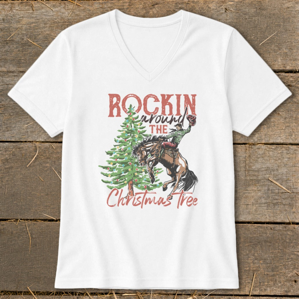 White t-shirt graphic with "Rockin' Around The Christmas Tree" and a rodeo rider on a bucking horse.