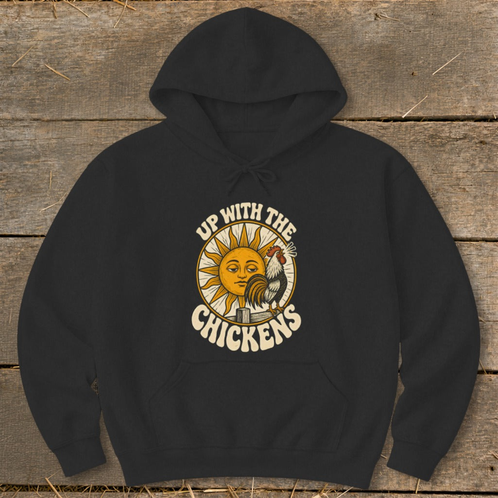 Black hooded sweatshirt featuring a graphic of a rooster, a sleepy sun, and the text Up With The Chickens.