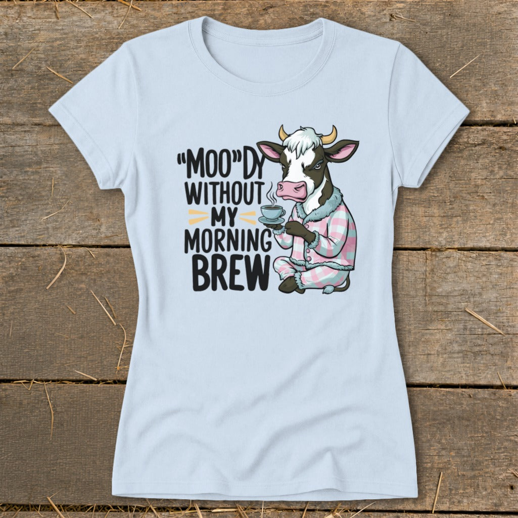 Light blue t-shirt with cartoon cow in pajamas holding coffee and text.