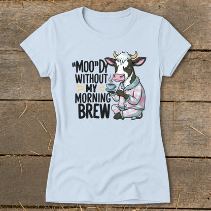 Light blue t-shirt with cartoon cow in pajamas holding coffee and text.