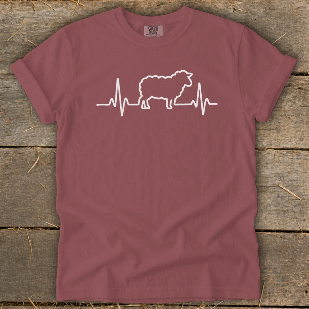A mauve t-shirt with a white graphic of a sheep integrated into a heartbeat line.