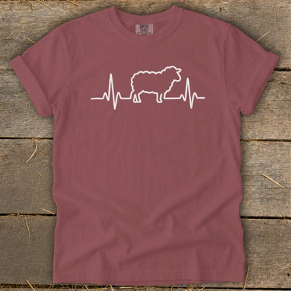 A mauve t-shirt with a white graphic of a sheep integrated into a heartbeat line.