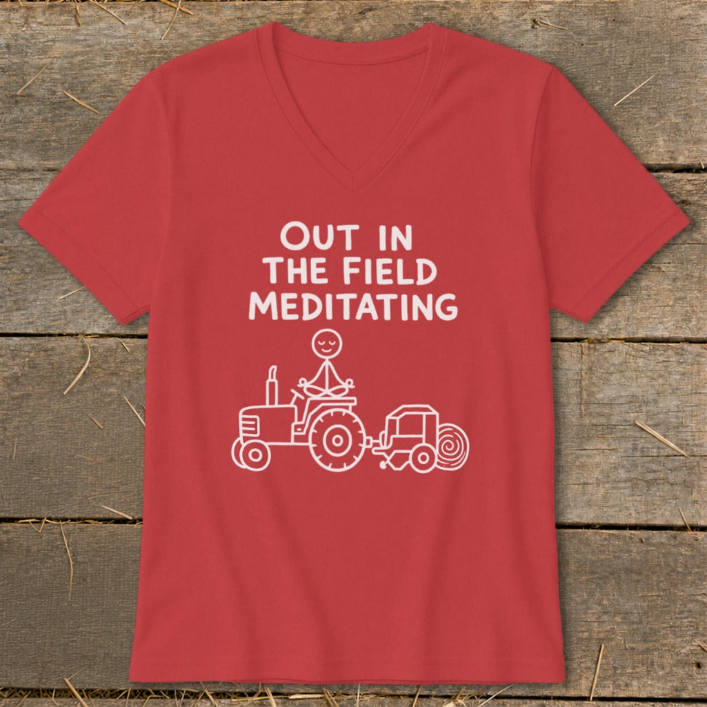 Red t-shirt with white text "OUT IN THE FIELD MEDITATING" and a stick figure meditating on a tractor.