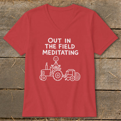 Red t-shirt with white text "OUT IN THE FIELD MEDITATING" and a stick figure meditating on a tractor.
