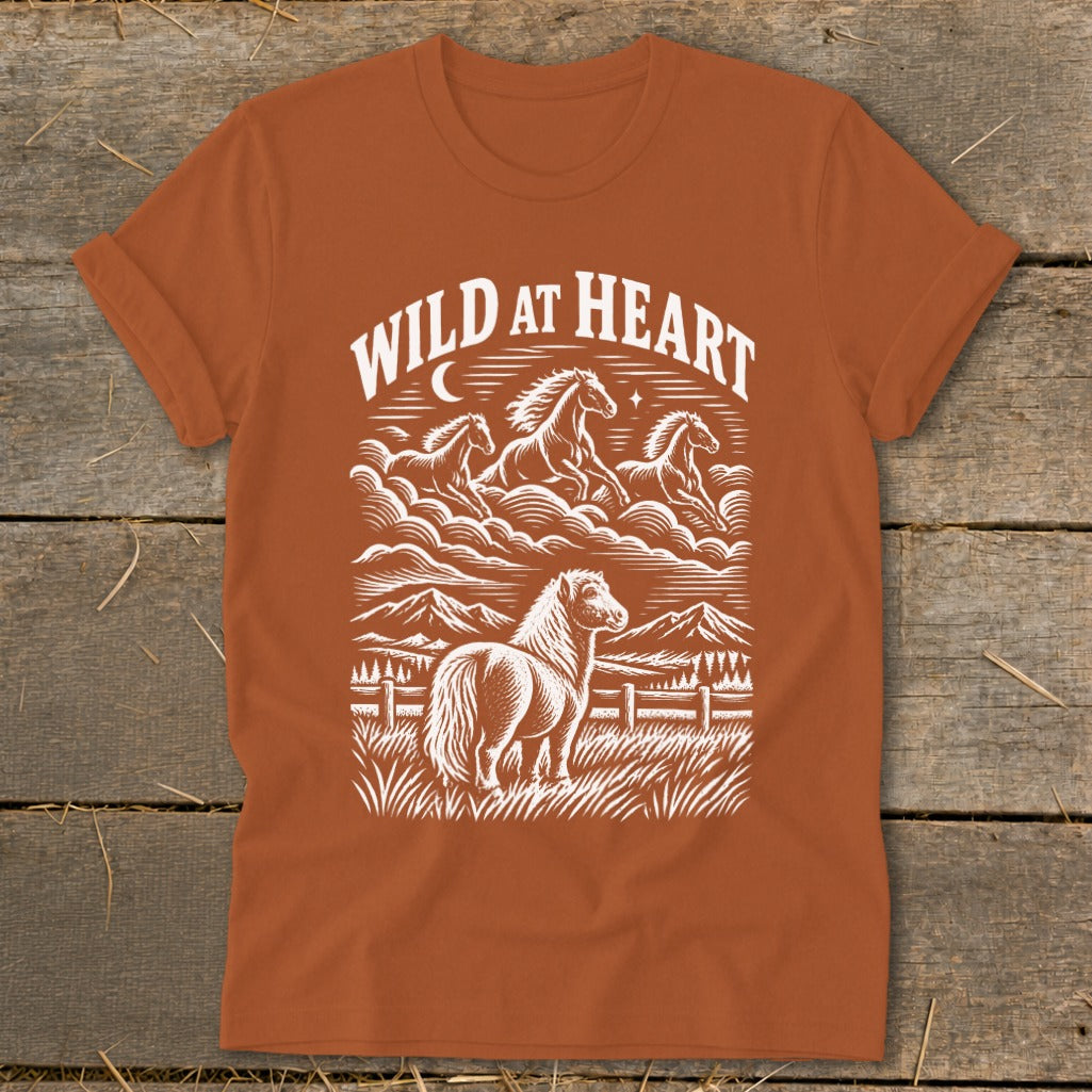 Orange t-shirt with white graphic of horses running and standing with text "Wild at Heart."
