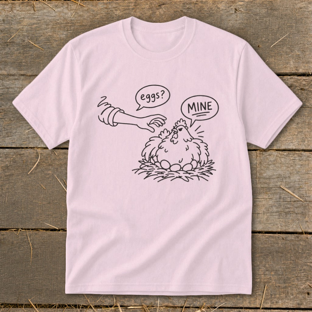 Line art on a pink t-shirt: a hand reaches for a chicken on a nest of eggs.