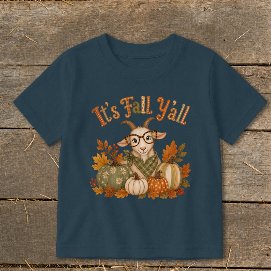 Dark blue children's t-shirt featuring a goat wearing glasses and a plaid scarf, surrounded by pumpkins, autumn leaves, and the text "It's Fall Y'all."