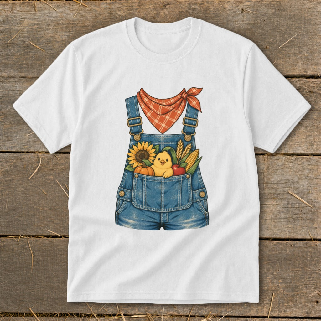 White t-shirt with illustration of overalls pocket filled with fall harvest and chick.