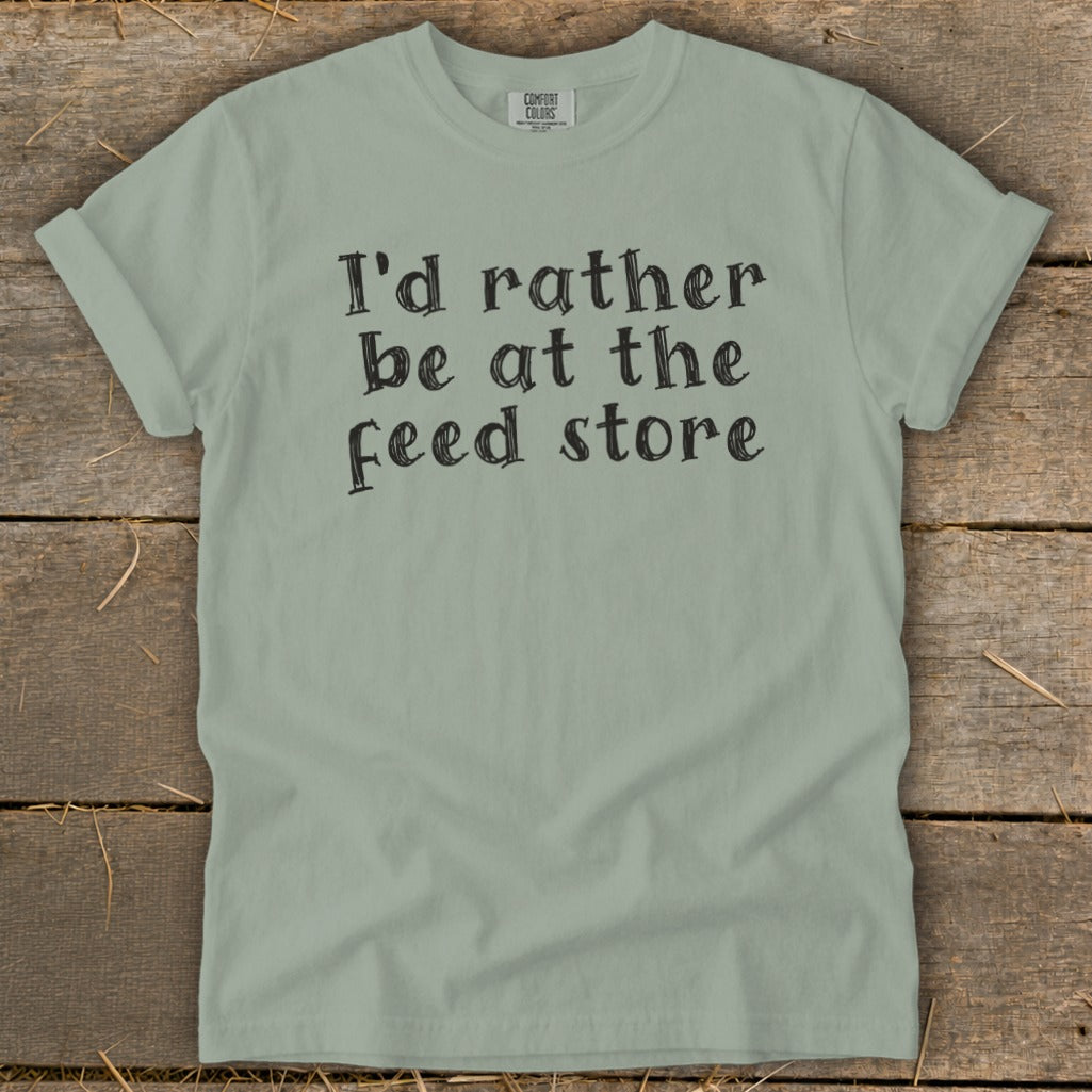 Light green Comfort Colors t-shirt with "I'd rather be at the feed store" text.